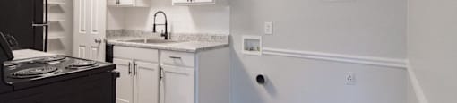 A kitchen with white cabinets and a black stove top oven.