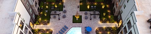 A swimming pool surrounded by buildings and lights at Liam at Hays Farm in Huntsville, Alabama