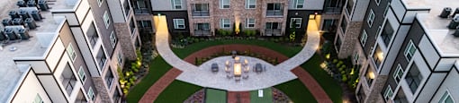 A courtyard surrounded by buildings with a fountain in the middle at Liam at Hays Farm in Huntsville, Alabama