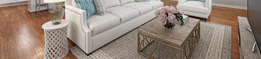 A living room with a white couch and a coffee table.