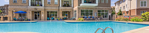 a swimming pool with an apartment building in the background