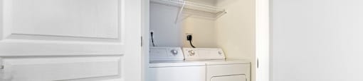 an empty laundry room with a washer and dryer in it
