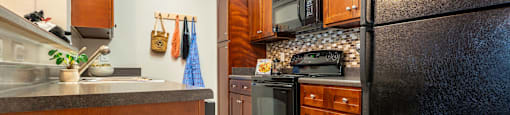 a kitchen with black appliances and wood cabinets