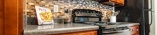 a kitchen with a stove and a microwave and wooden cabinets
