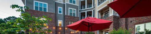 A patio with a table and chairs and umbrellas.