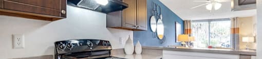 Dark wood kitchen cabinetry with a black refrigerator and tile backsplash at Midora at Woodmont in Tamarac, FL