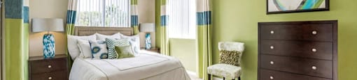 Spacious bedroom with plush carpeting and large window at Midora at Woodmont in Tamarac, FL