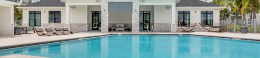 A large swimming pool in front of a house.