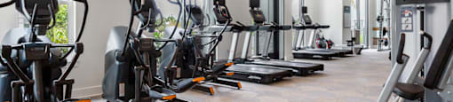 A gym with treadmills, elliptical machines, and stationary bikes.