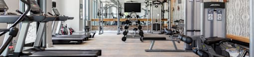 A gym with treadmills, elliptical machines, and other exercise equipment.