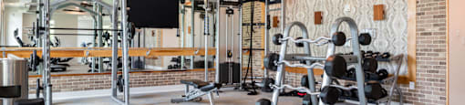 A gym with a variety of equipment including weights and a treadmill.