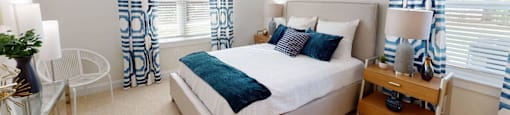 a bedroom with a bed and windows with curtains