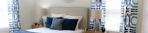 a bedroom with blue and white curtains and a bed
