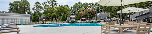 our apartments have a large pool and patio with tables and chairs