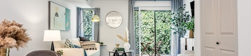 a living room with white walls and a sliding glass door