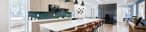 a communal kitchen with a marble counter top and bar stools