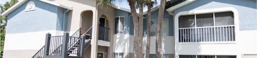 Beautiful building exterior of Park Village- blue and white buildings with palm trees