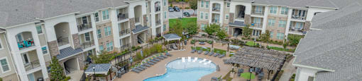 an aerial view of an outdoor pool area with apartment buildings
