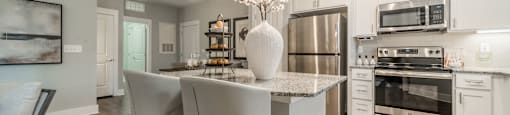 a kitchen with stainless steel appliances and a marble counter top