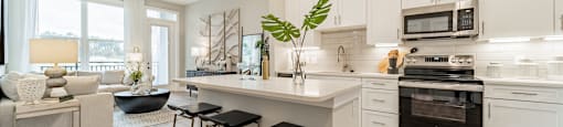 A modern kitchen with white cabinets and a large island.