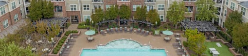 an aerial view of a large swimming pool in front of an apartment building