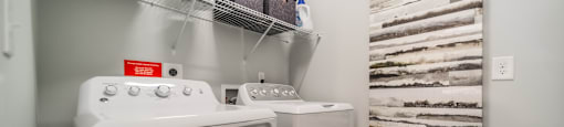 a washer and dryer in a laundry room with a shelf over the was