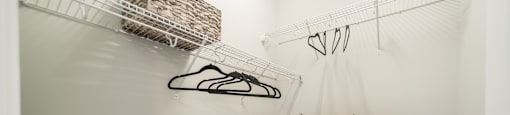 a walk in closet with a pair of shoes and baskets