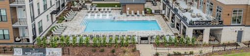 A large apartment complex with a pool in the middle.