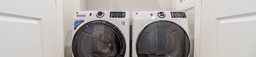 Two front loading washing machines in a laundry room.