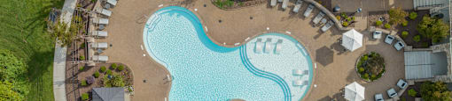 an overhead view of a swimming pool at a resort with umbrellas