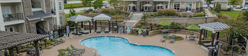 an aerial view of a large swimming pool with lounge chairs