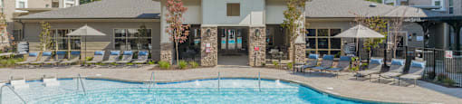 our apartments have a resort style pool with chairs and umbrellas