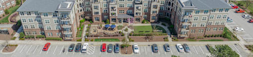 an aerial view of a large apartment complex with cars parked in the parking lot
