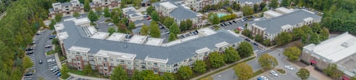 an aerial view of a parking lot with buildings and trees