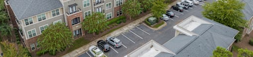 an aerial view of an apartment complex with cars parked in a parking lot