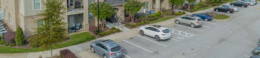 an aerial view of an apartment complex with cars parked in a parking lot
