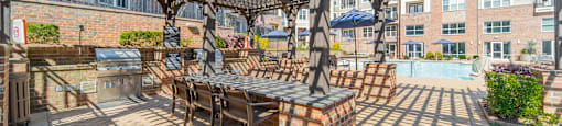 a pergola with a table and chairs on a brick patio