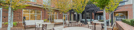 a patio with tables and chairs outside of a brick building