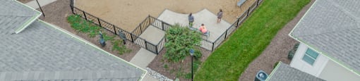 an aerial view of a fenced in dog park in a residential neighborhood