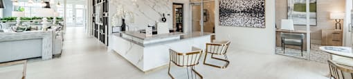 A modern kitchen with a marble backsplash and wooden chairs.
