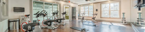 a home gym with exercise machines and a tv on the wall