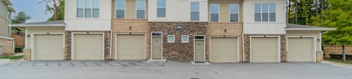 a large white and tan house with garage doors