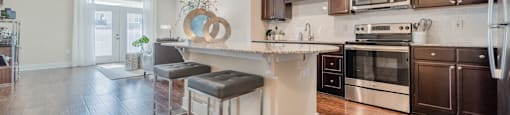 a kitchen with a large island with two stools in front of it