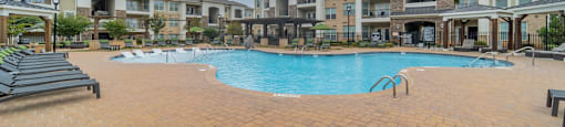 a large swimming pool in front of an apartment building