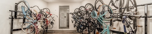 a row of bikes hanging on the wall in a room with wooden floors