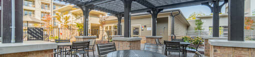 a patio with tables and chairs under a pergola