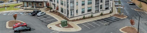 A large white building with a parking lot in front.