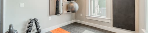 a workout room with exercise equipment and a window