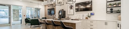 a kitchen with a long island with bar stools and exposed wood beams