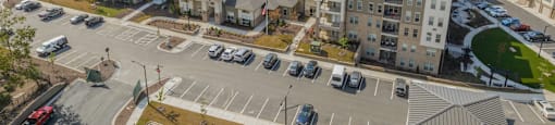 an aerial view of an apartment complex with cars parked in a parking lot
